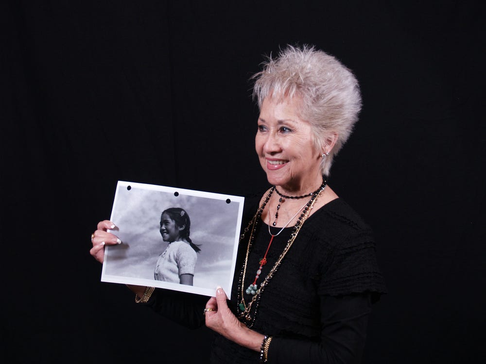 Smiling woman holding a photograph
