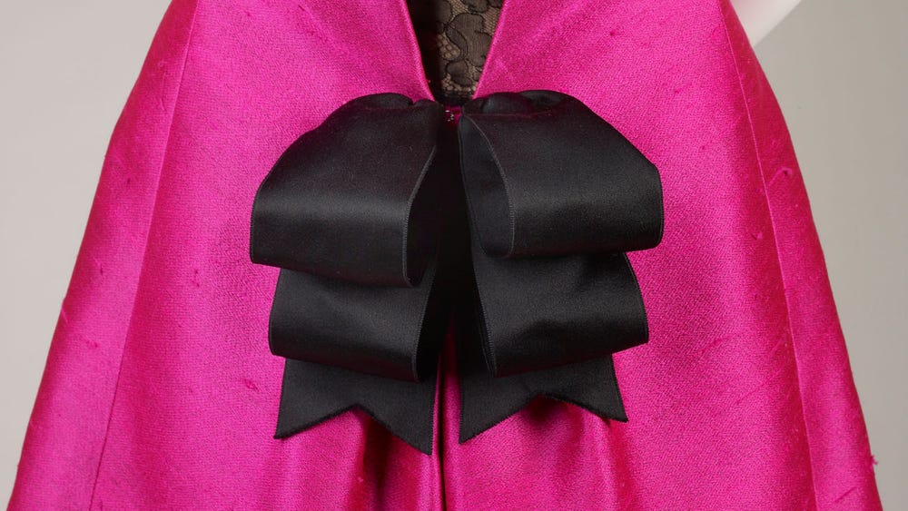 Pink dress with black lace and black bow.