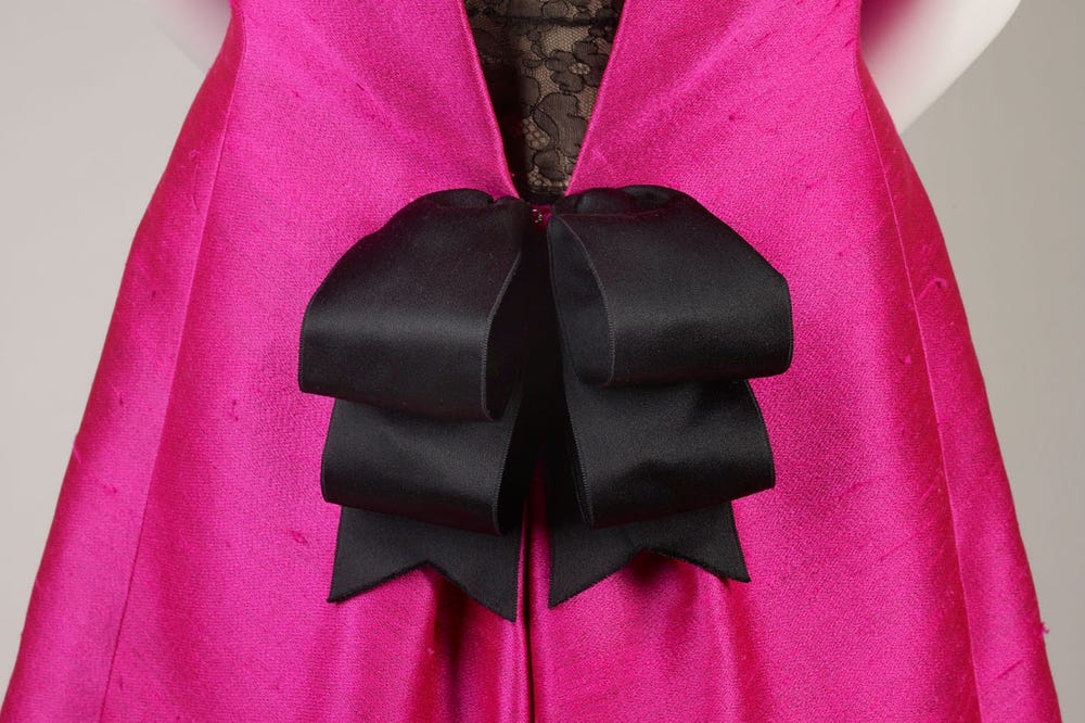 Pink dress with black lace and black bow.