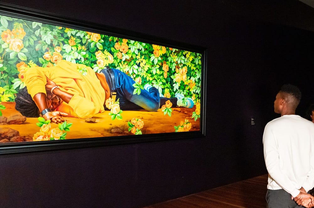 Visitors looking at artwork by Kehinde Wiley in de Young museum gallery