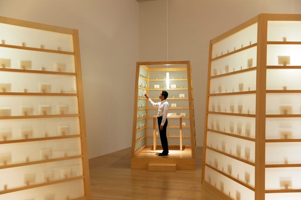 Lee Mingwei looking at letters in letter writing project installation