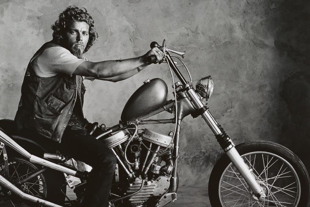 Black and white photograph of a rock musician on a motorcycle by Irving Penn
