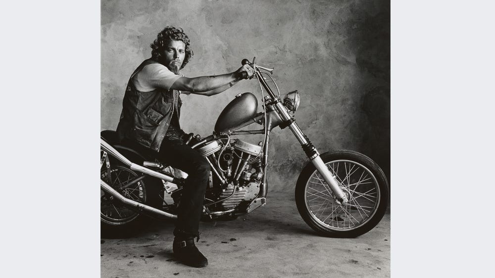 Black and white photograph of a rock musician on a motorcycle by Irving Penn