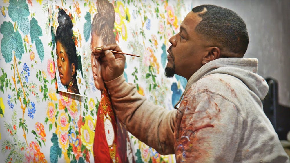 Kehinde Wiley holding a paint brush to a painting
