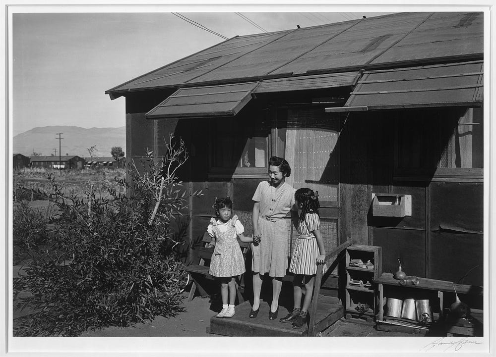 Woman and two children standing outside a house