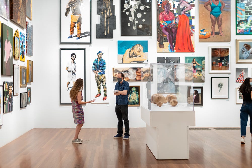 People in a de Young gallery with artworks